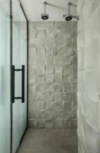 Banheiro com chuveiro duplo e box com detalhes em preto