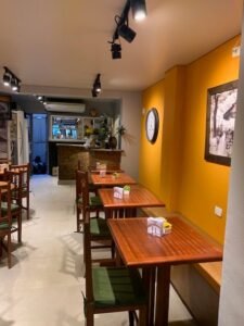 cafeteria com parede amarela e quadros pendurados